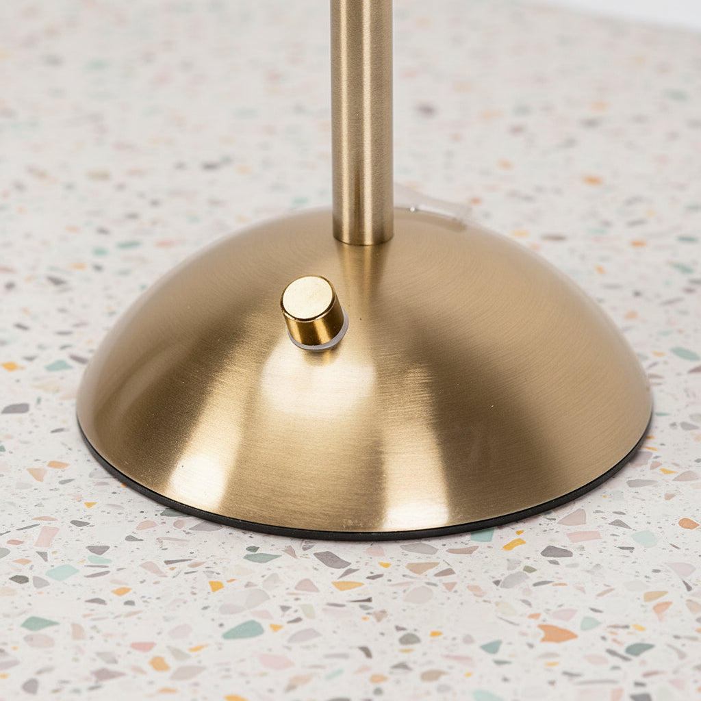 Close up of a light switch on a gold stemmed table lamp.