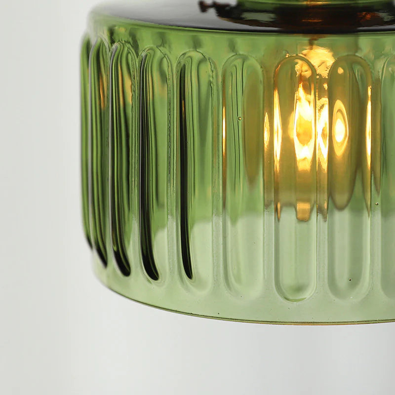 Green glass candle holder with ribbed design on a white background