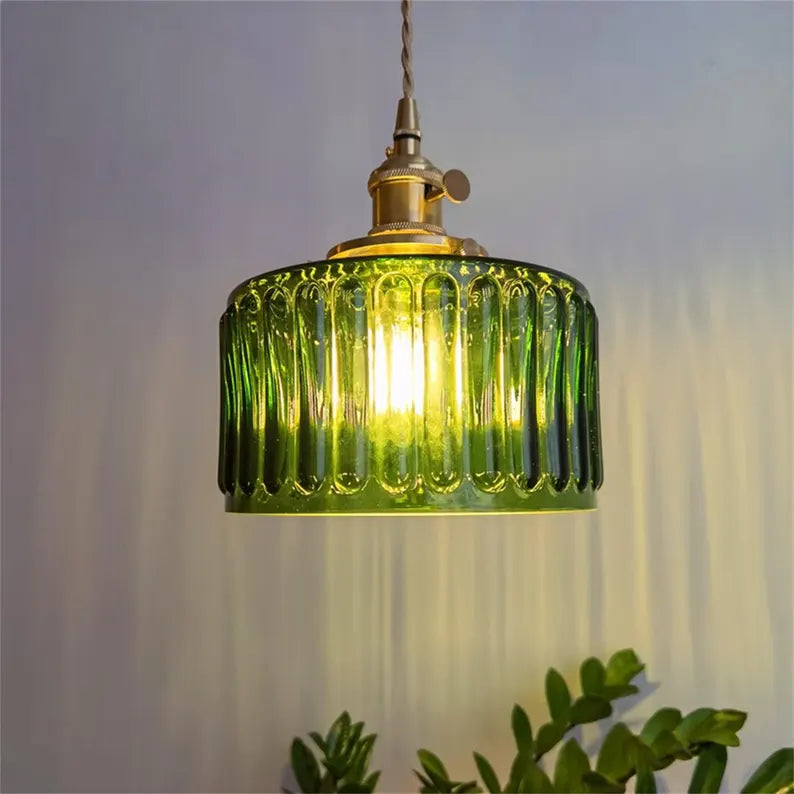 Green pendant light with ribbed design on a neutral background