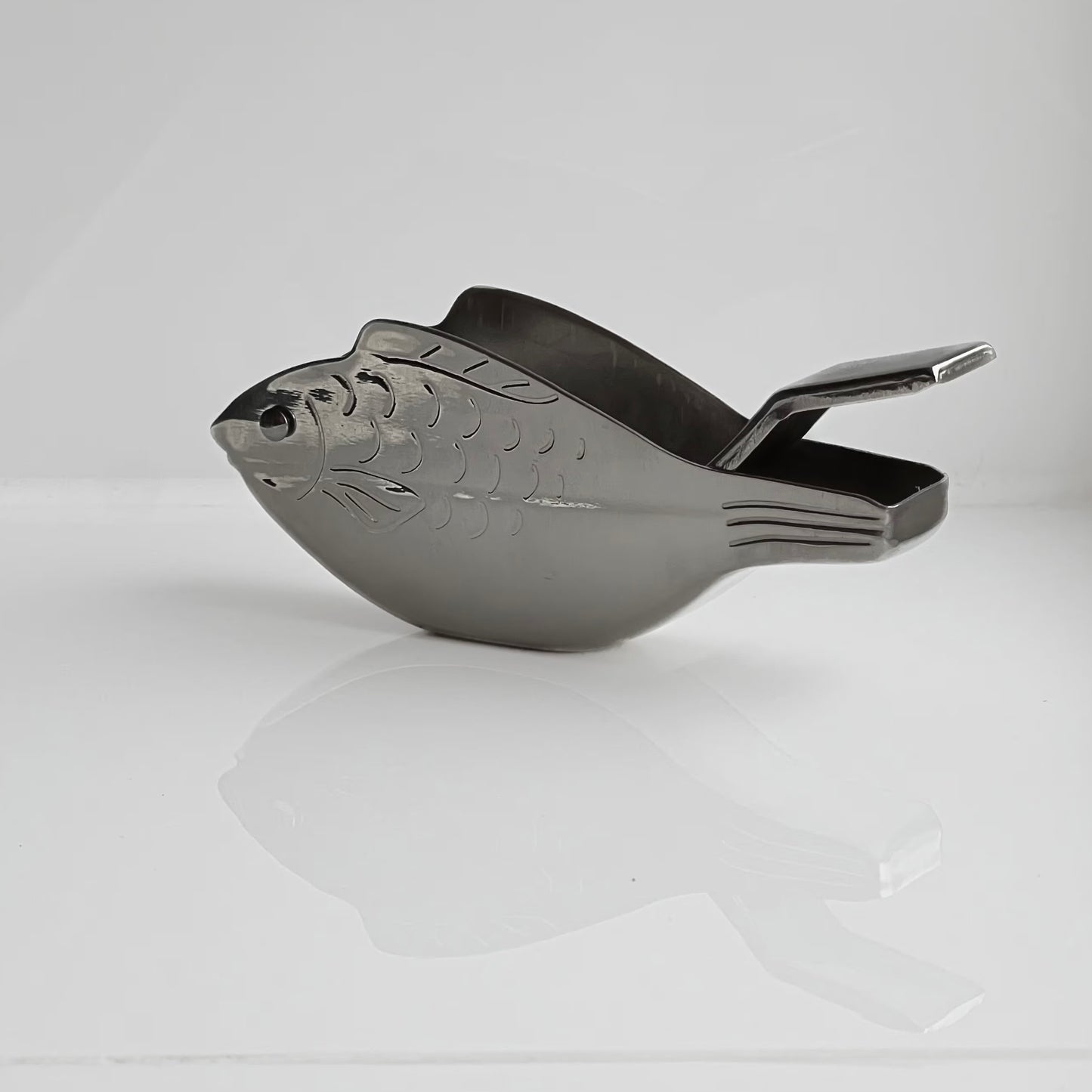 Metallic scoop with decorative design on a white background
