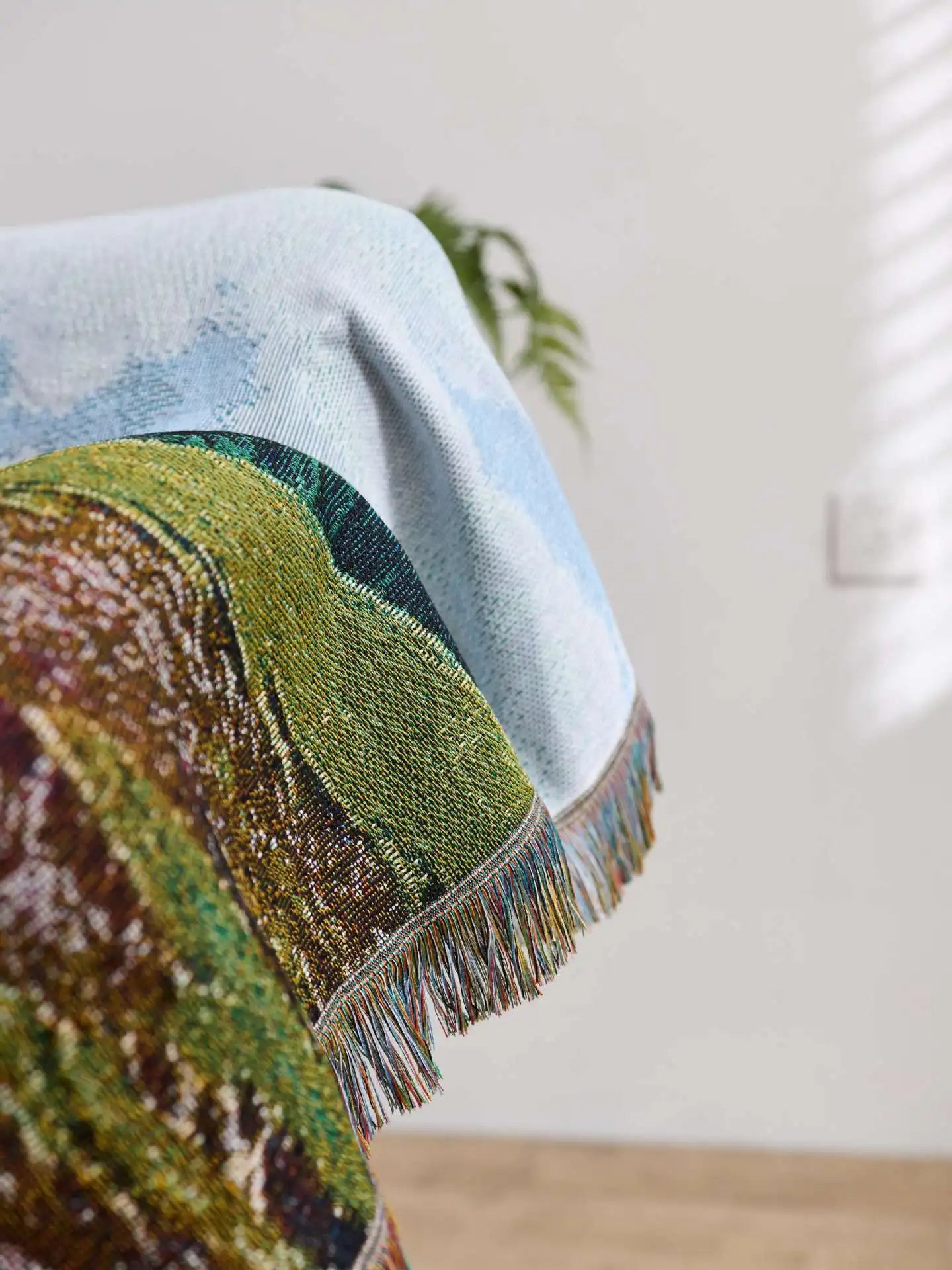 Textile with landscape design and fringes on a neutral background