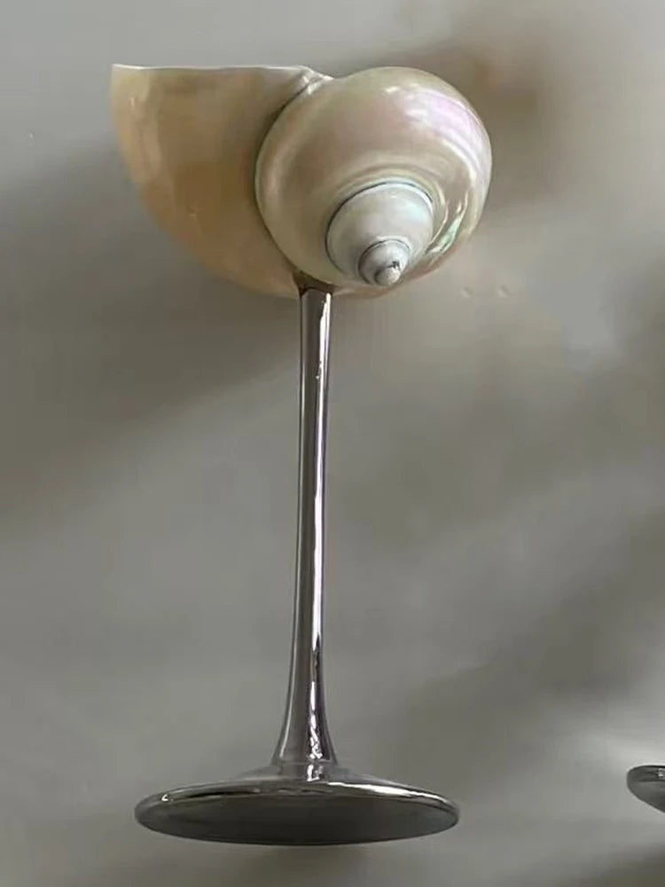 Ceiling light fixture with a metallic base and beige cover on a gray ceiling.