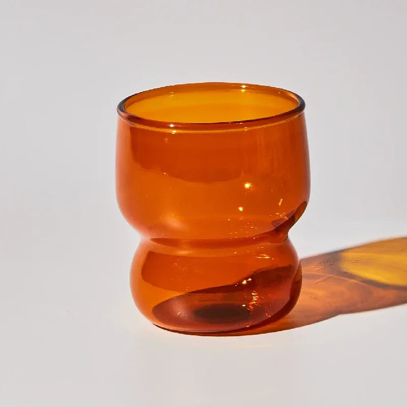 Orange glass cup on a white background