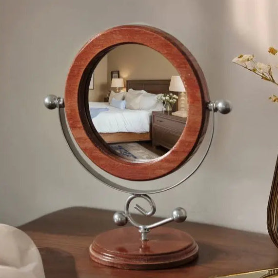 Wooden stand mirror on a table with a blurred background