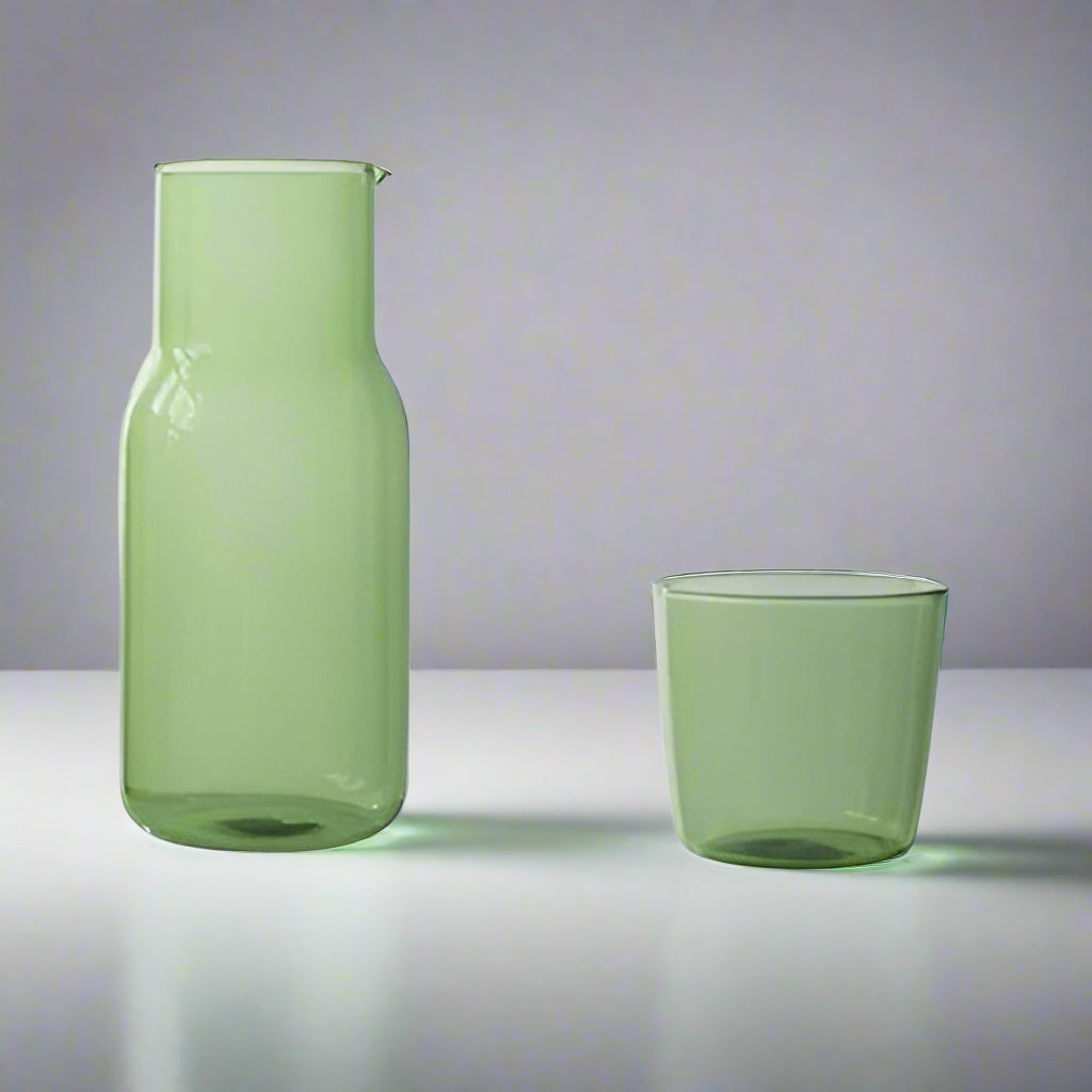 Green glass carafe and cup with measurements on a white background