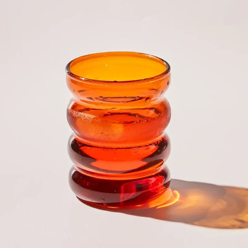 Orange glass drinking cup on a white background