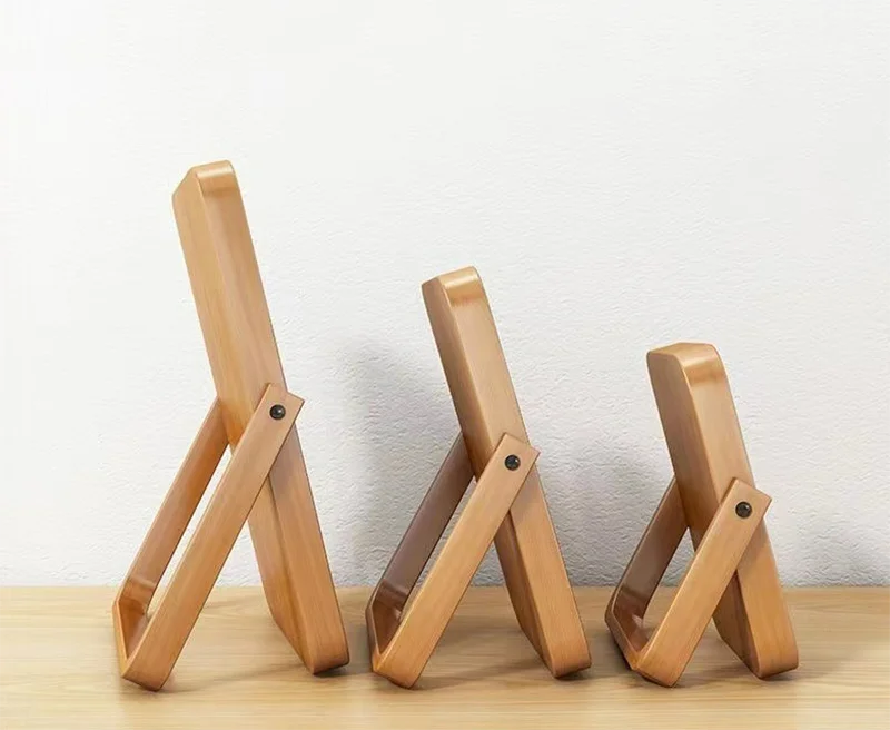 Three wooden mirrors of different sizes on a light surface with a white background