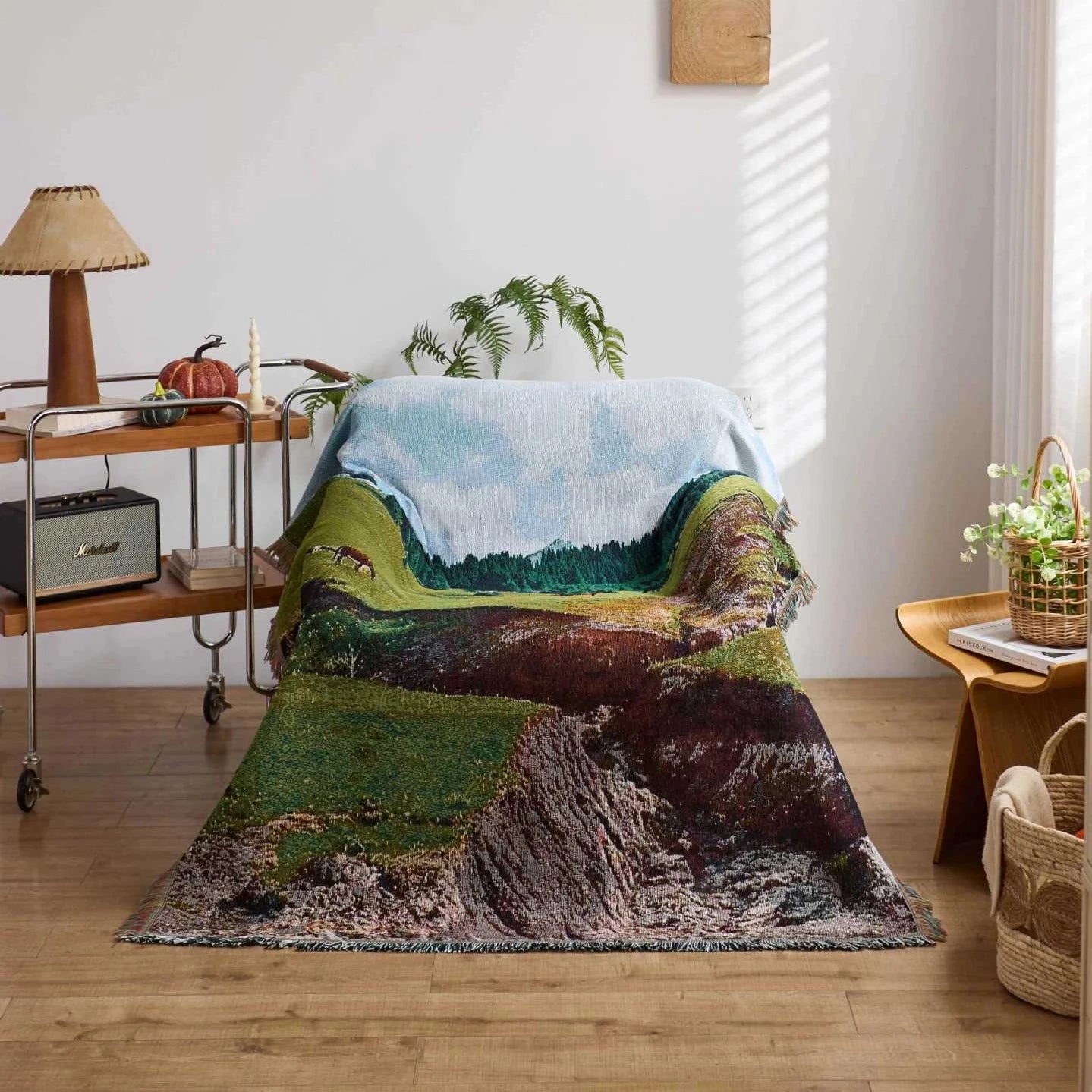 Nature-themed blanket draped over a chair in a room with wooden flooring and decor.