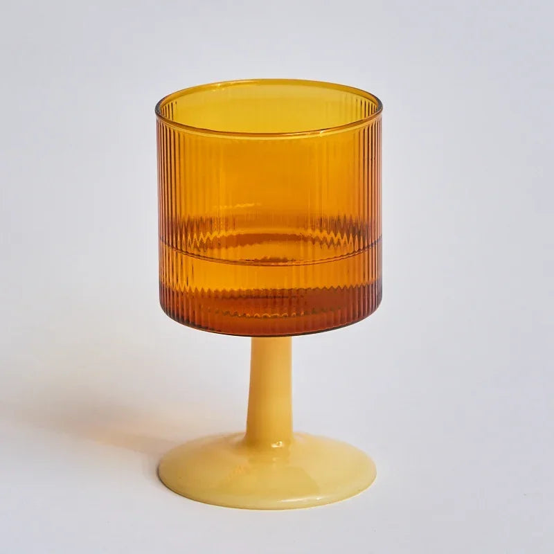 Amber glass with a pedestal base on a light gray background