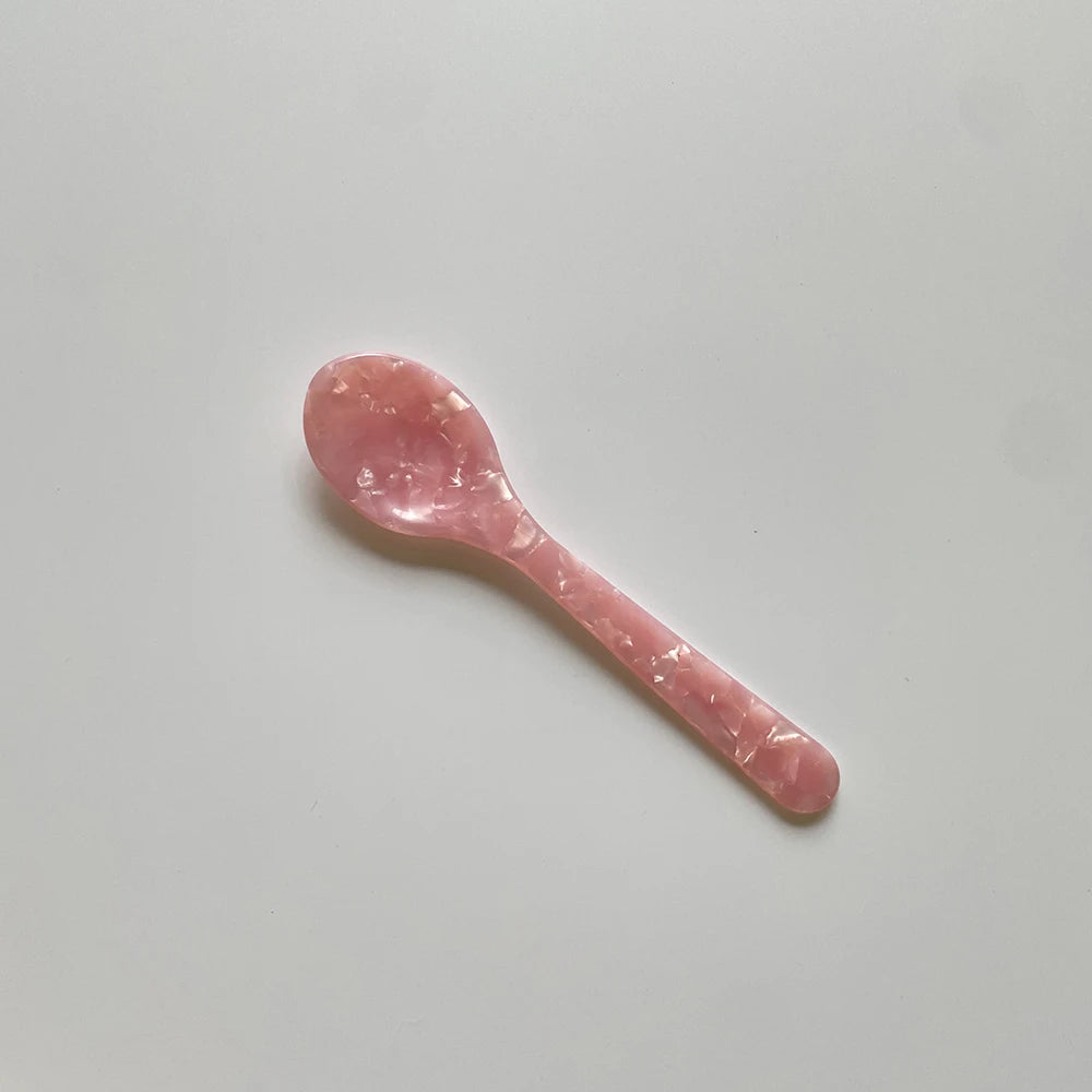 Pink spoon on a light gray background