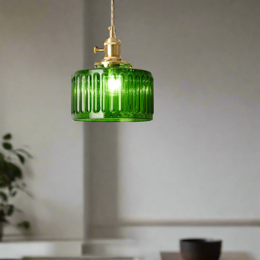 Green pendant light hanging above a dining table with flowers and decorative items.