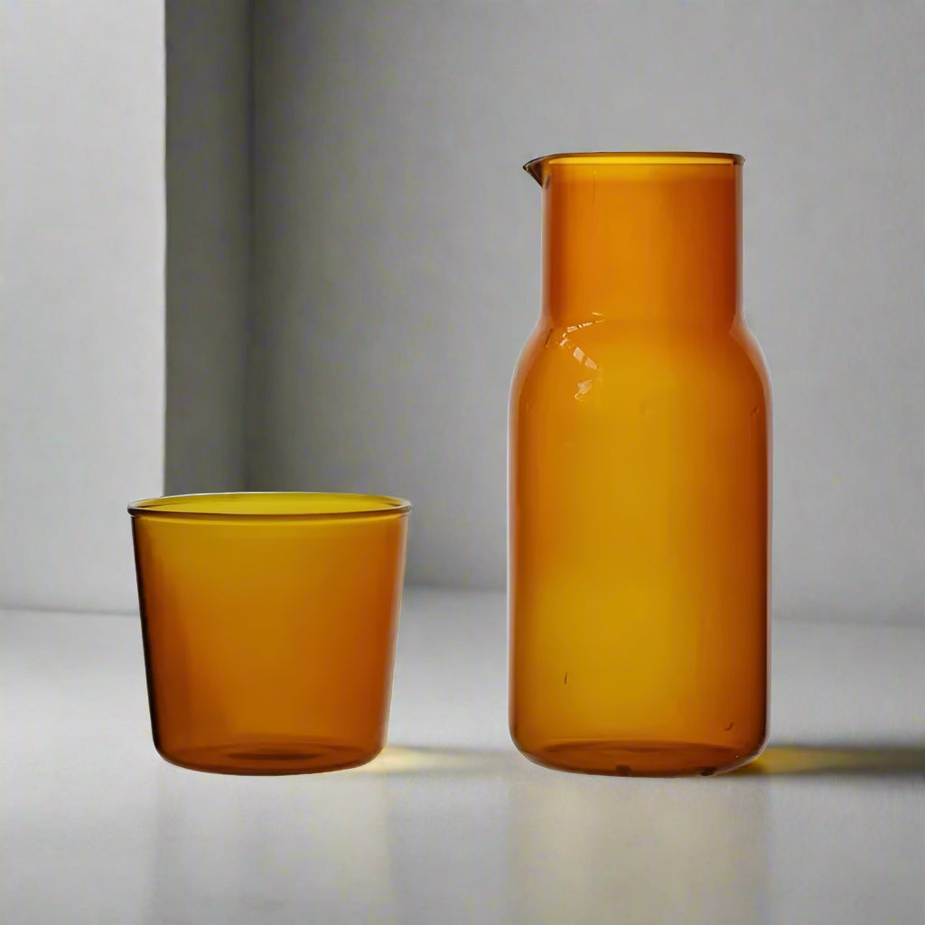 Amber glass carafe and tumbler on a white background