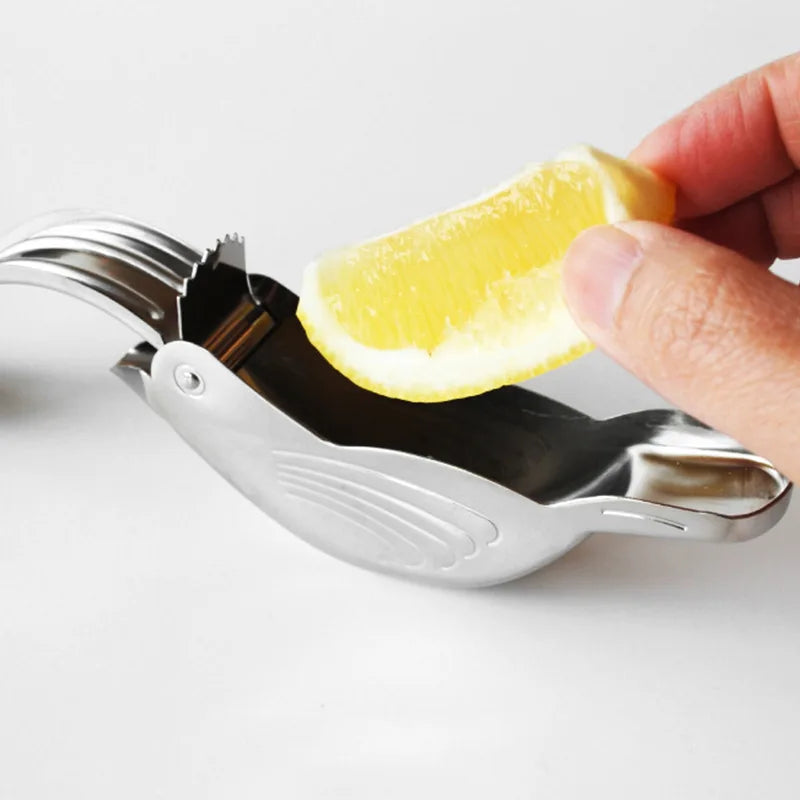 Metallic lemon squeezer with a lemon wedge being squeezed on a white background