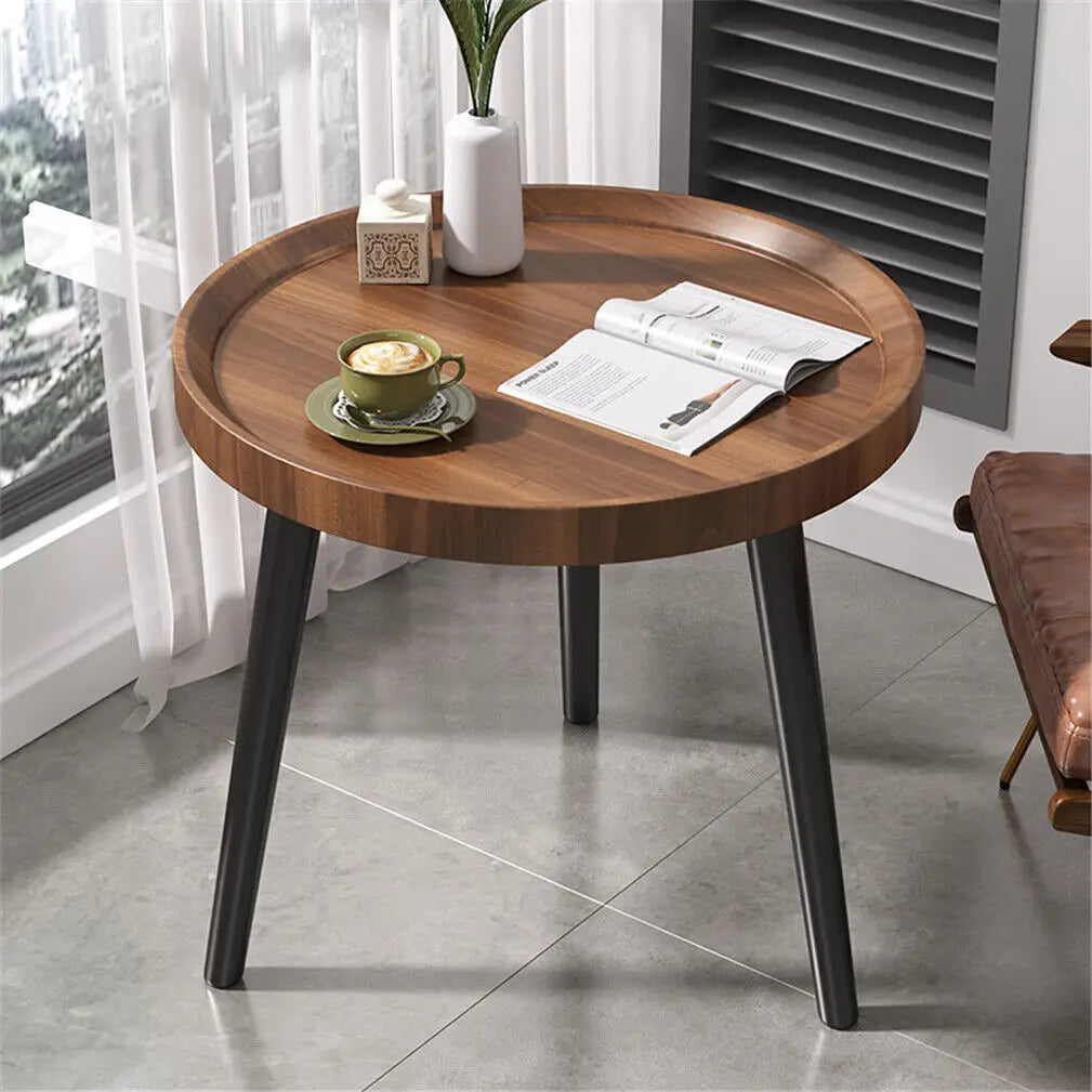 Round wooden table with a cup of coffee and newspaper in a room with a window and curtain.