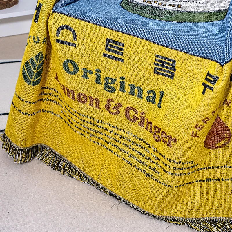 Yellow blanket with branding and text on a light wooden surface