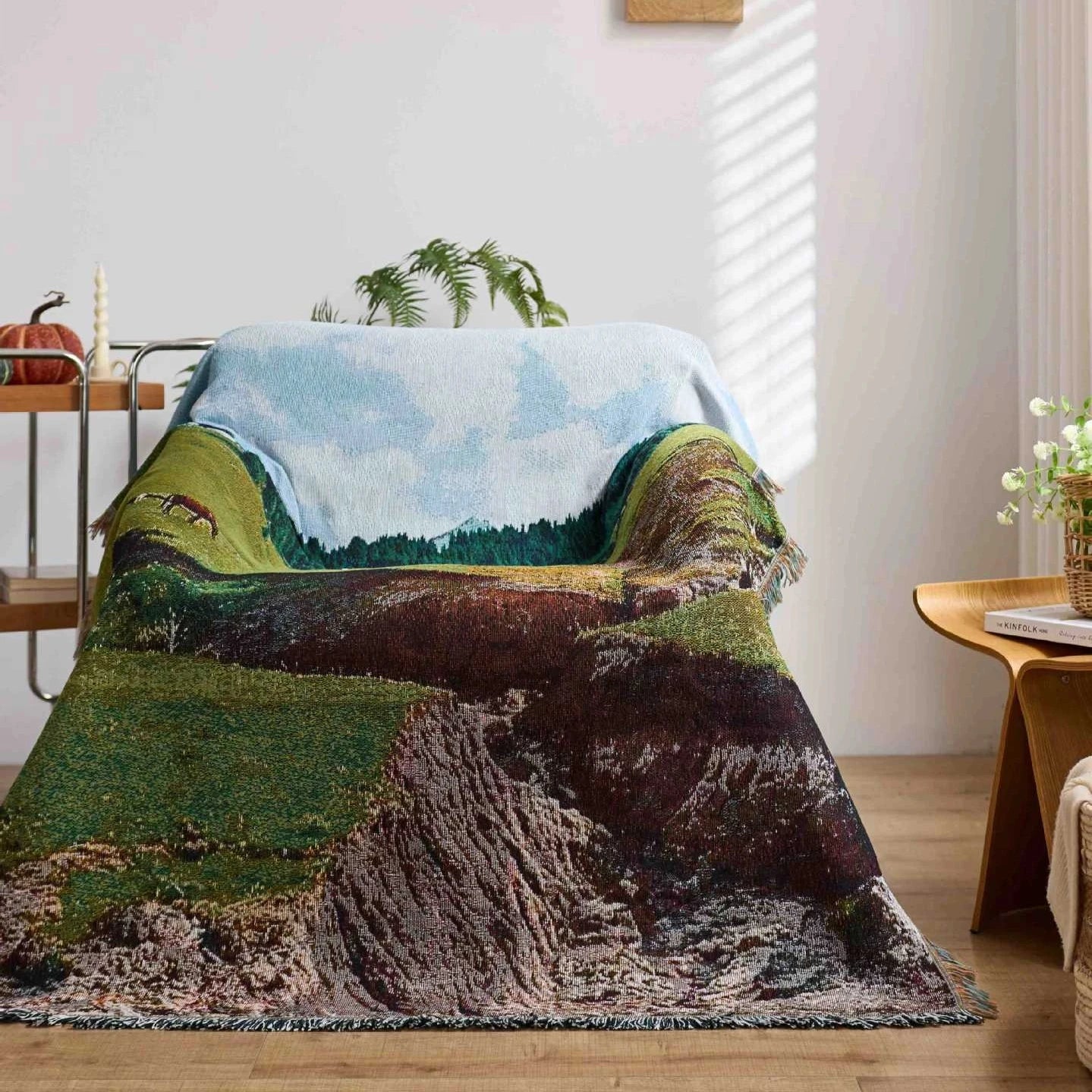 Nature-themed blanket draped over a chair in a room with decor elements.