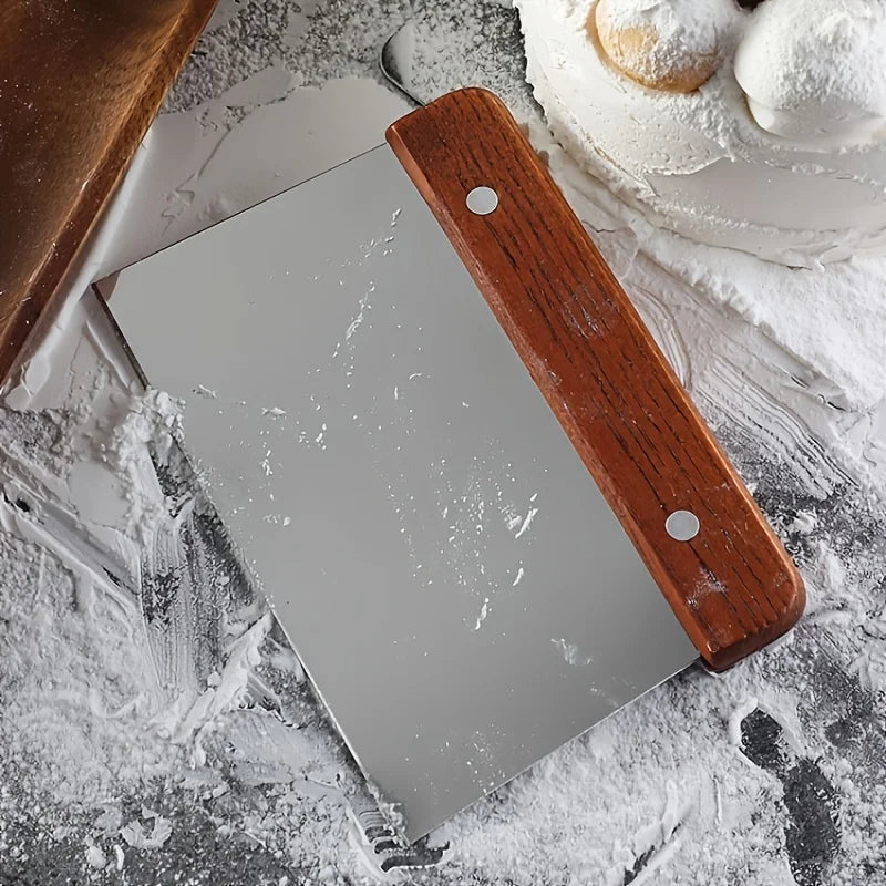 Metal cleaver with wooden handle on a flour-dusted surface