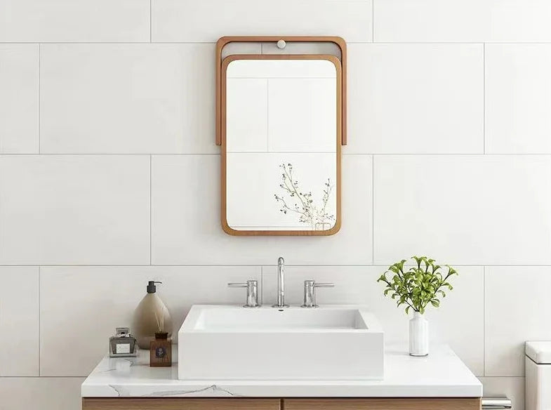 Bathroom vanity with a mirror, sink, and decorative items on a white tiled wall.