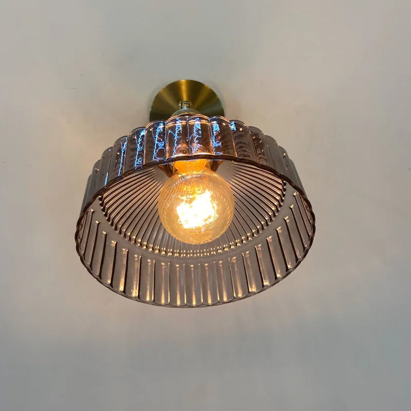Ceiling light fixture with a metallic finish on a plain background