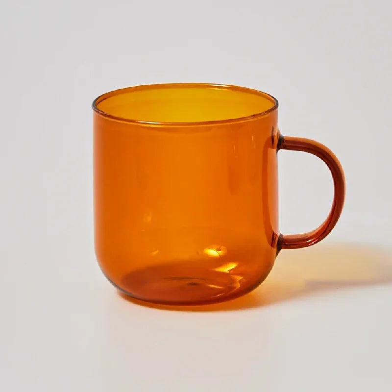 Orange glass mug on a light gray background