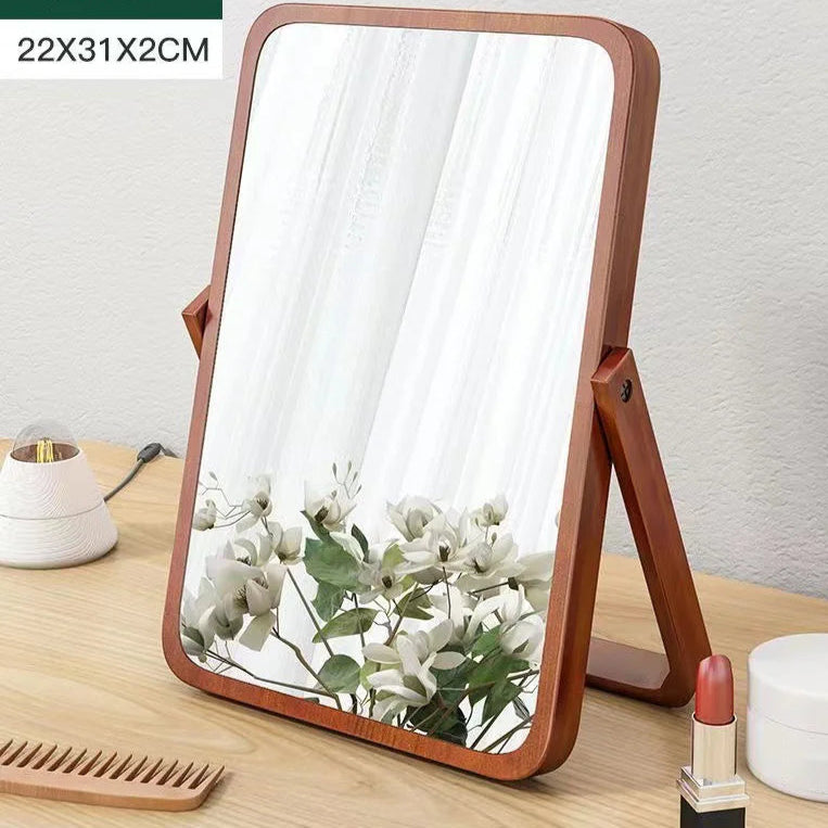 Wooden-framed mirror on a wooden surface with decorative items.