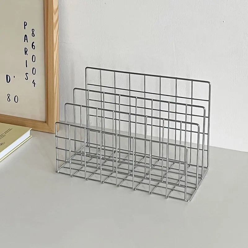 Metal wire desk organizer on a white surface with a light gray wall background