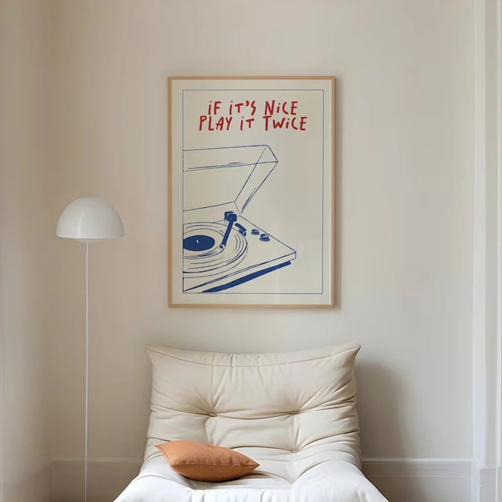 Framed artwork with text above a cushioned chair in a room.
