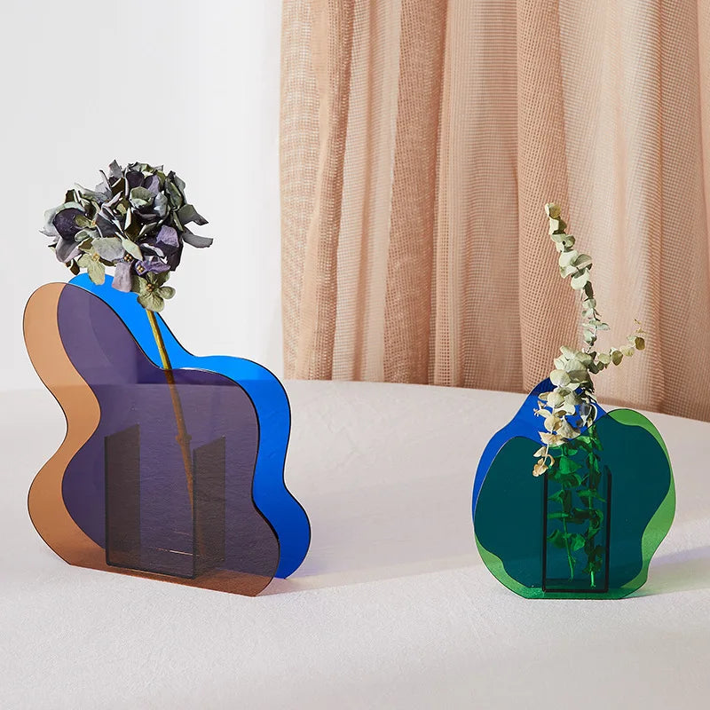 Two blue vases of different shapes on a white table with beige curtains behind