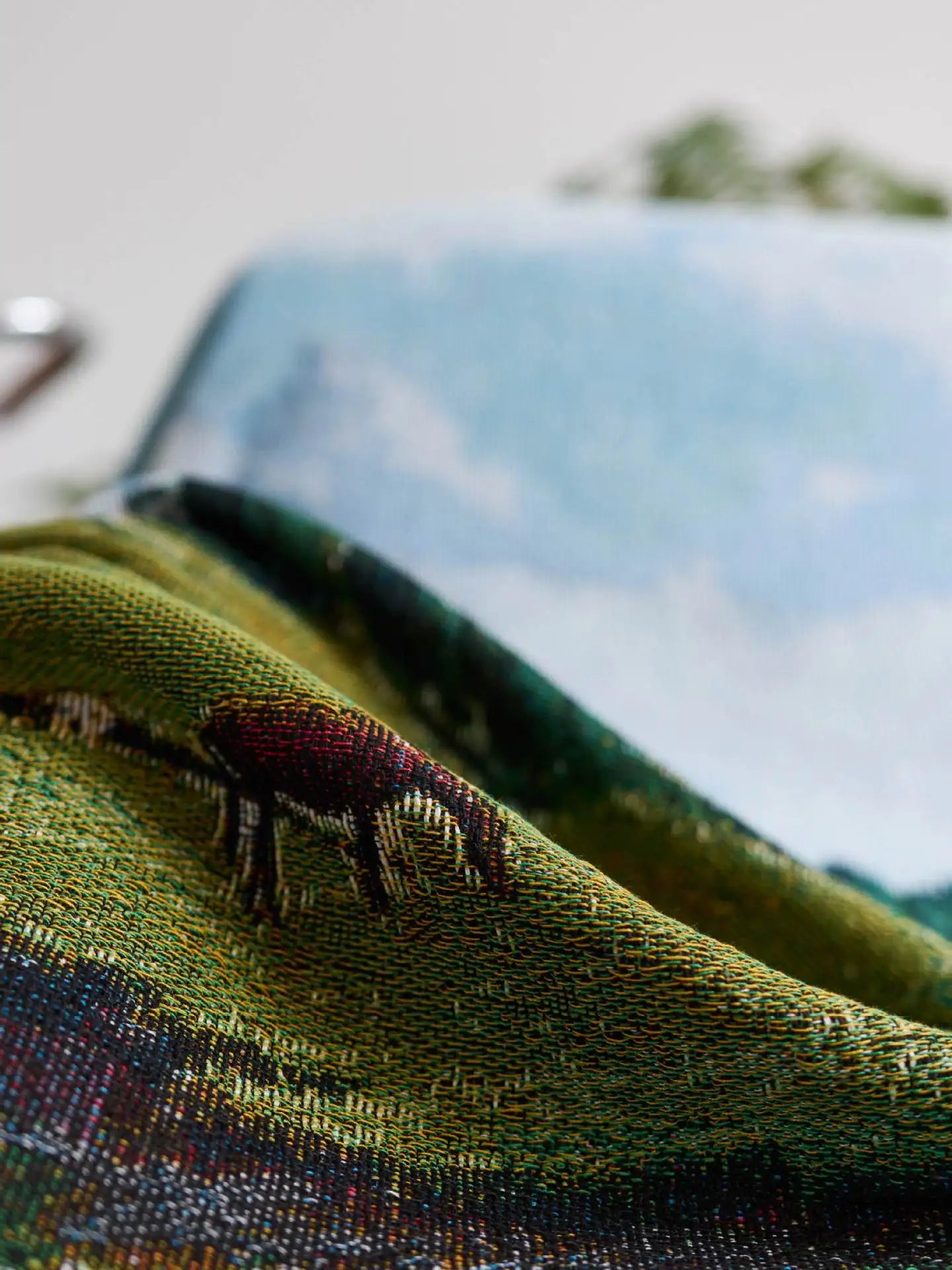 Close-up of a textured fabric with a small embroidered design on a blurred background