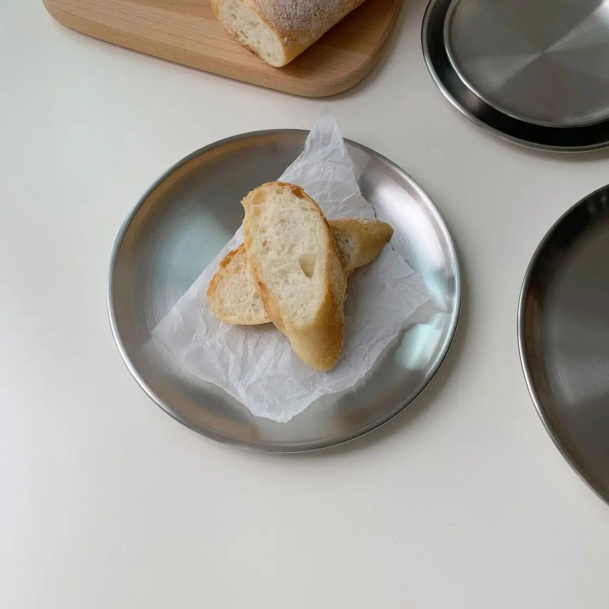 Two slices of bread on a metal plate with a white background