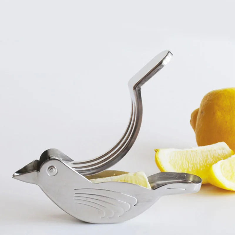 Metallic bird-shaped lemon squeezer with lemons on a light background