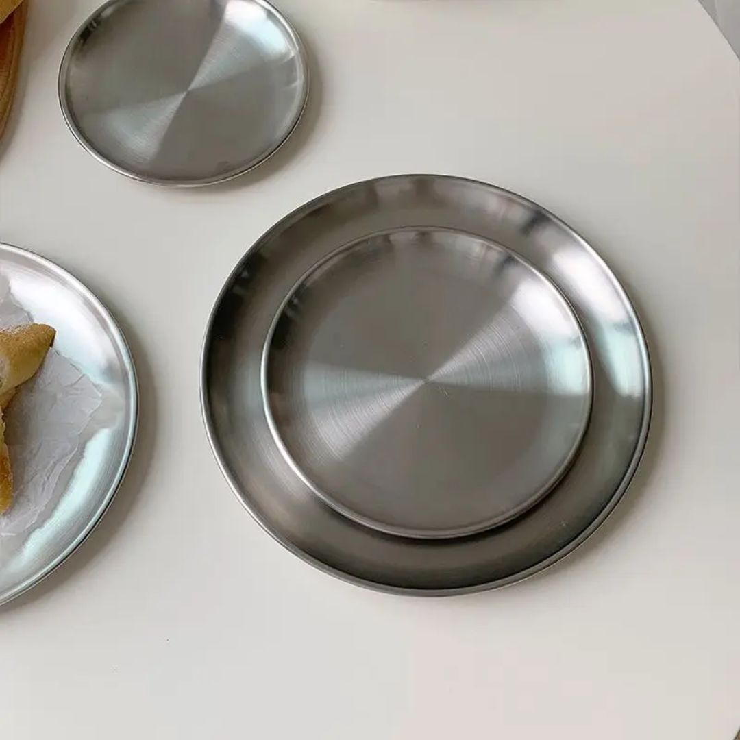 Stainless steel plates on a white surface