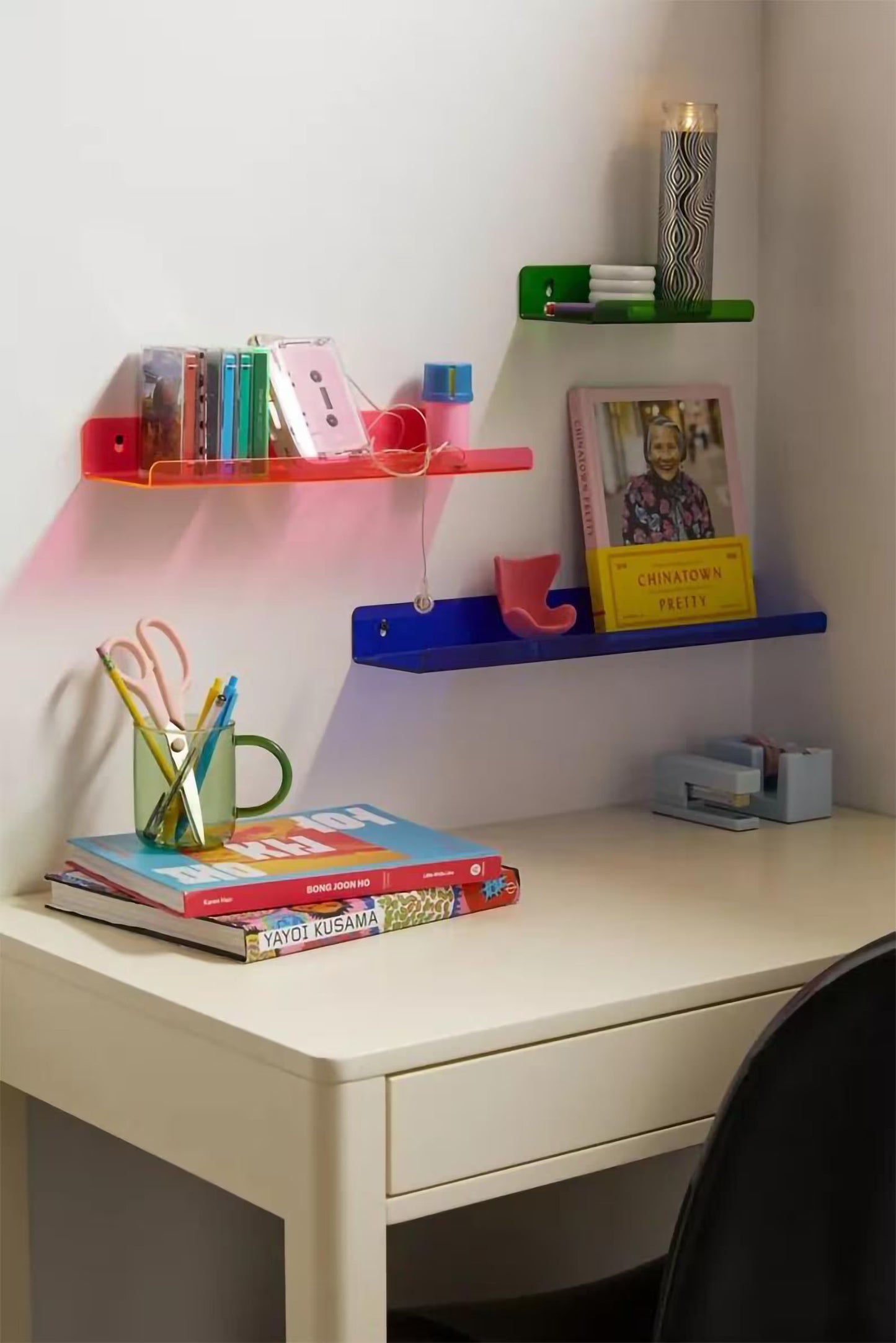 Desk with colorful shelves and stationery items in a home office setting