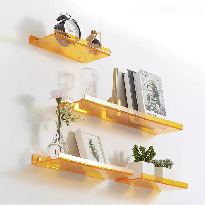 Set of orange shelves with decorative items on a white wall