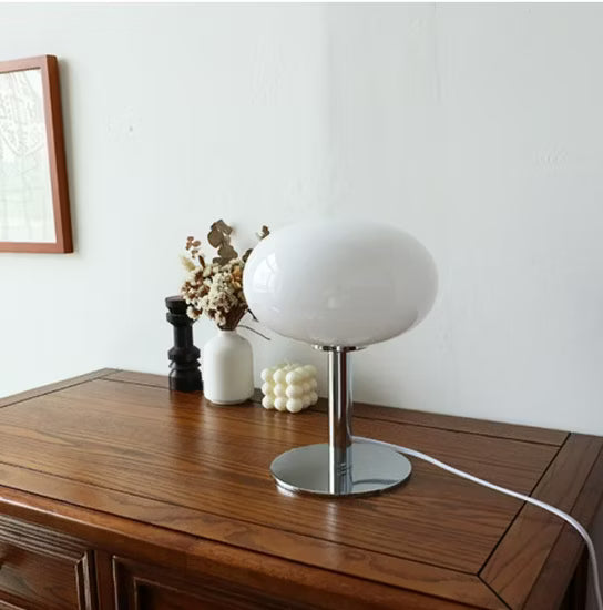 White table lamp on a wooden surface with a minimal background