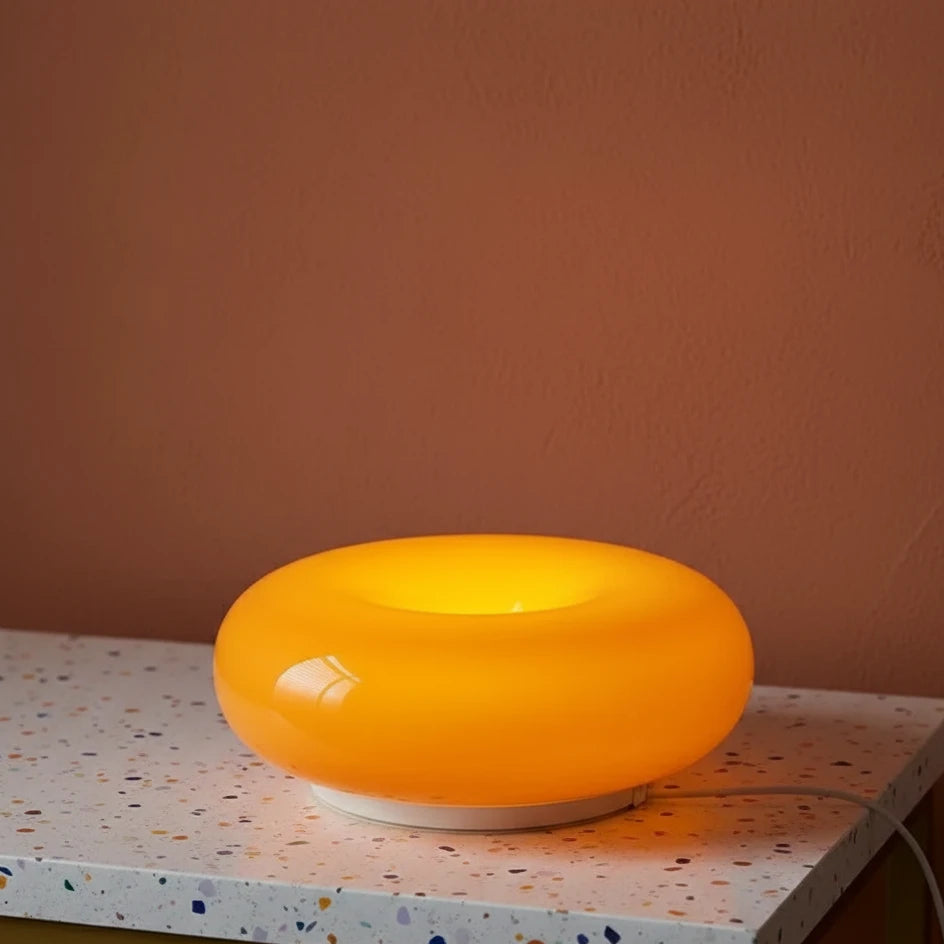Orange lamp on a speckled surface with a brown wall background