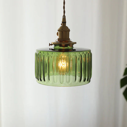 Green glass pendant light with brass fitting on a white background