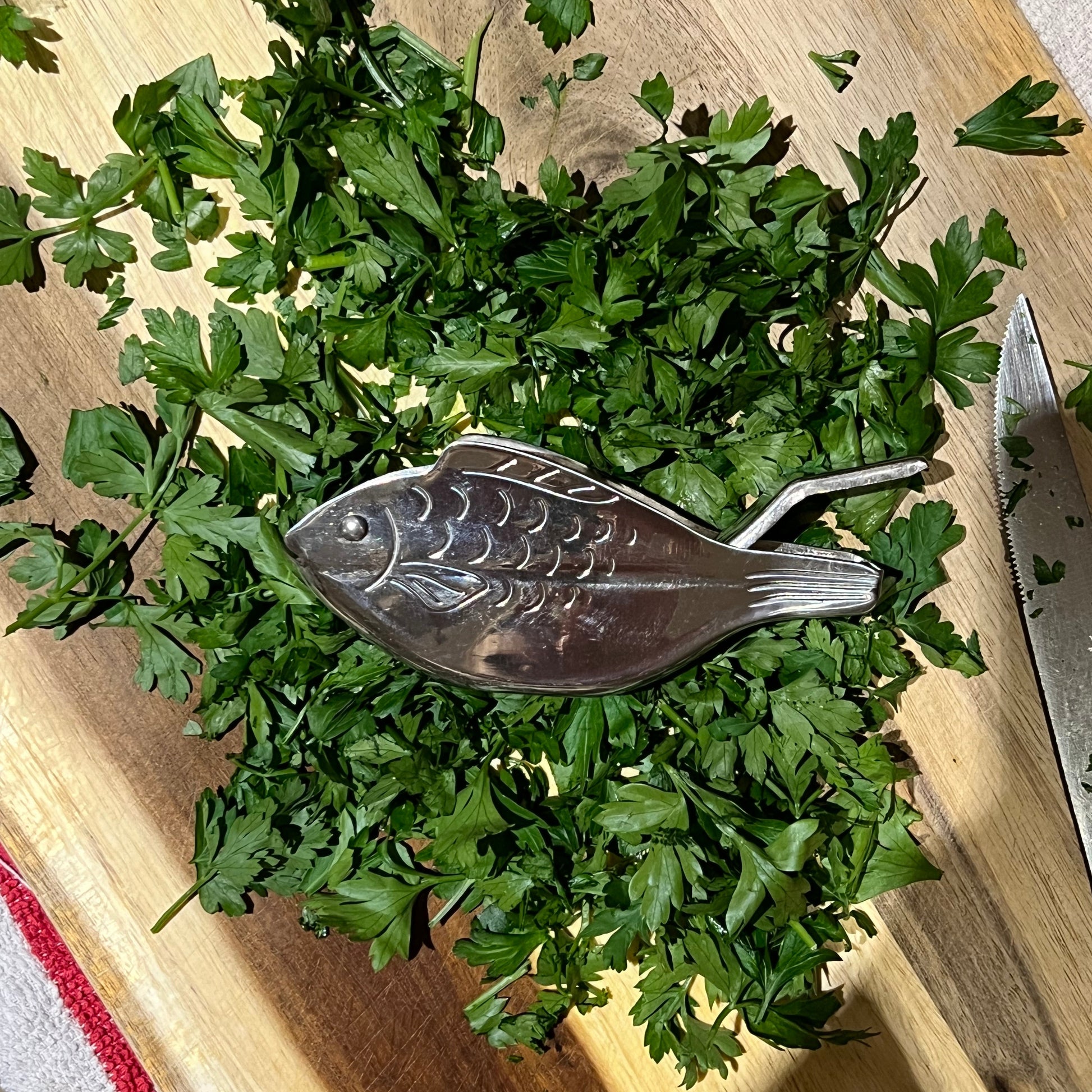 Chopped parsley on a wooden cutting board with a decorative spoon