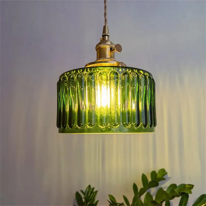 Green pendant light with ribbed design on a neutral background