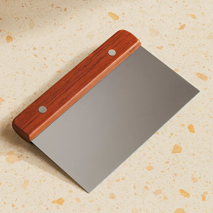 Metal tool with wooden handle on a textured beige background