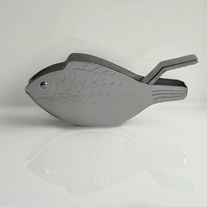 Gray fish-shaped tool on a light gray background