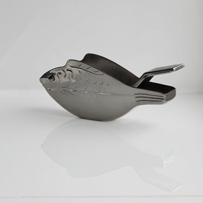 Metallic scoop with decorative design on a white background