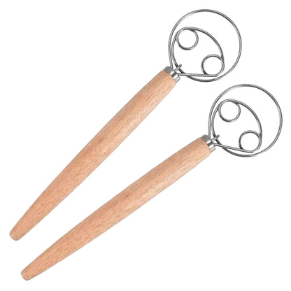 Two dough scisors with wooden handles on a white background, with a basket of bread in the corner.