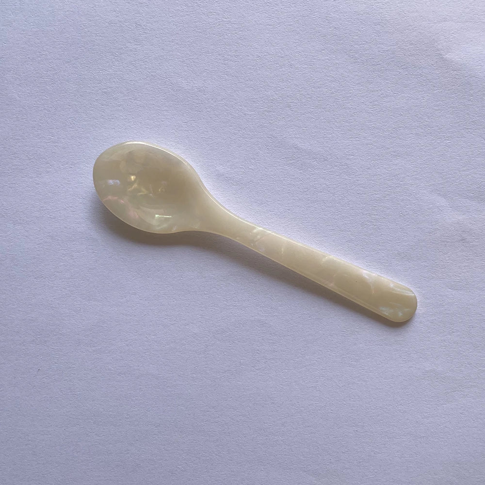 White ceramic spoon on a light gray background