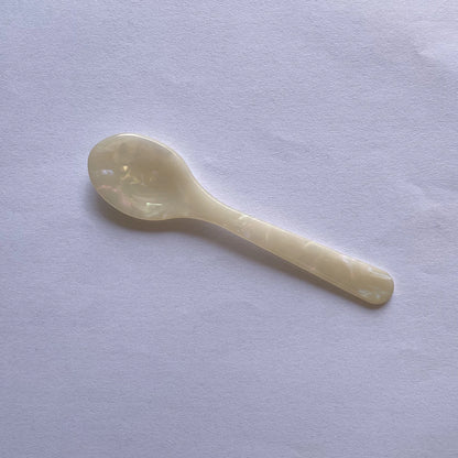 White ceramic spoon on a light gray background