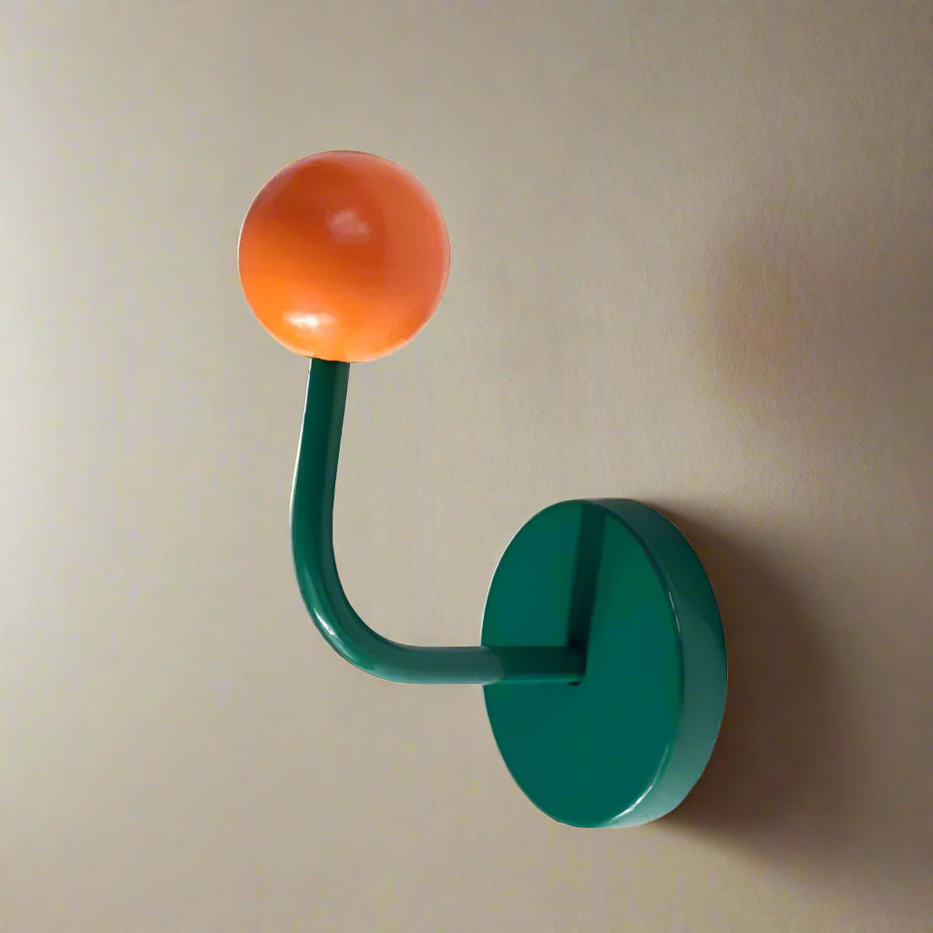 Green hook with an orange ball on a white background