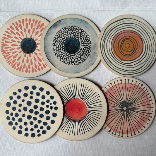 Set of six circular coasters with abstract patterns on a light background