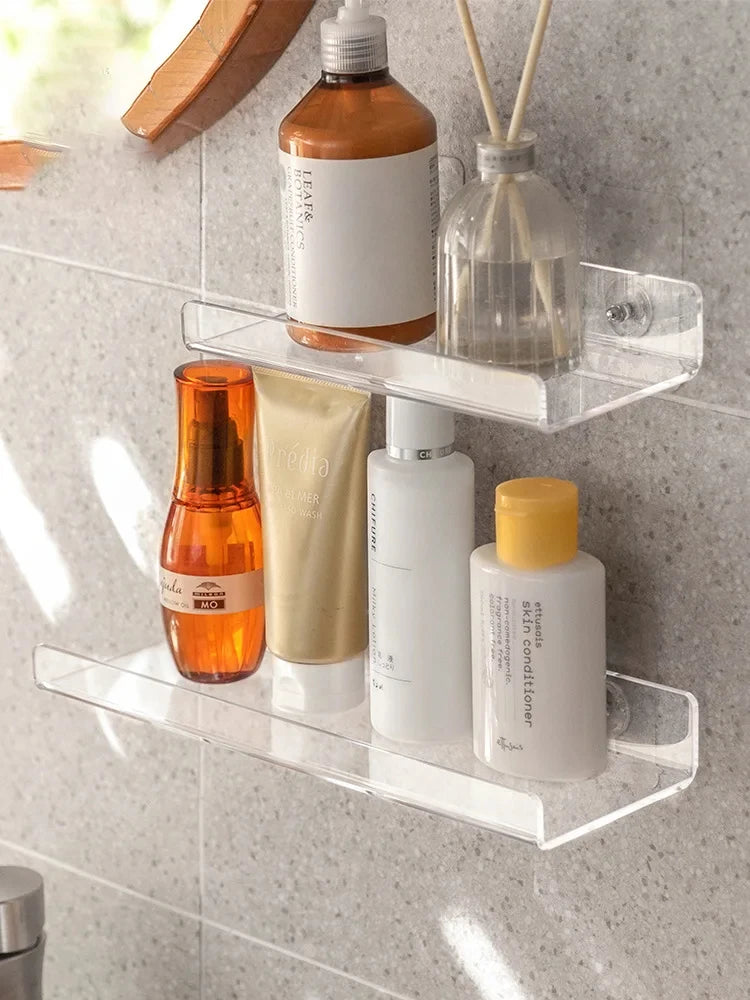 Clear acrylic shelves in a bathroom holding products