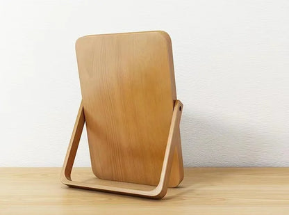 Back of a wooden mirror on a wooden surface with a white background