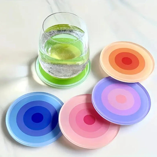 Colorful silicone coasters with a glass of water on a white surface